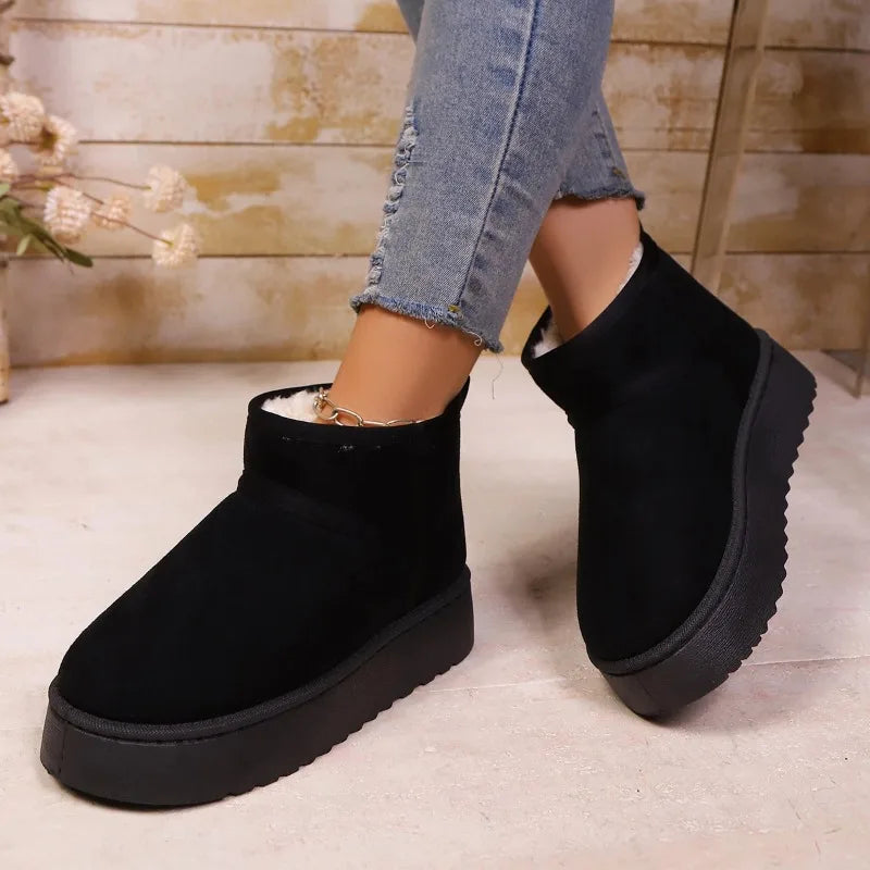 Black platform mini boots worn with cropped jeans